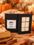 Reign Candle Pumpkin Cheesecake wax melts in black packaging beside pumpkin cheesecake and pumpkins