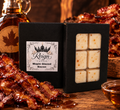 Reign Candle Maple Glazed Bacon wax melts in black packaging beside glazed bacon and maple syrup